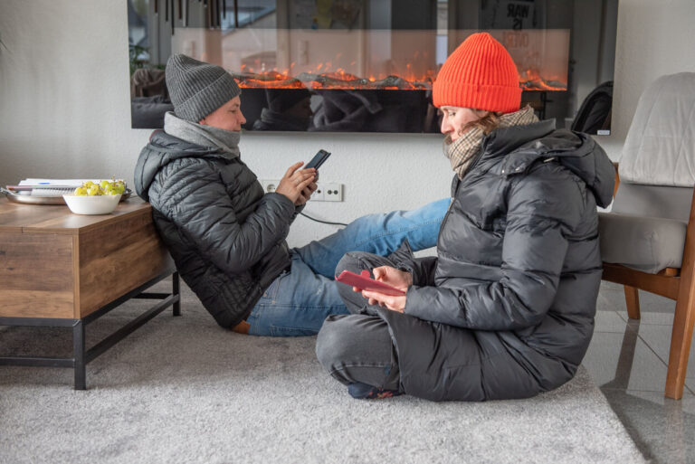 Photo: Couple bundled up indoors trying to stay warm